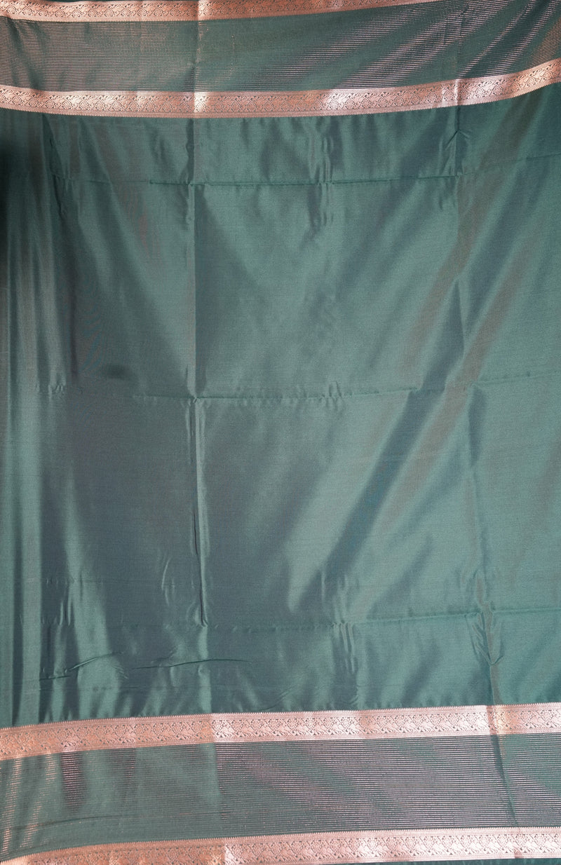 A dark green silk saree fabric with metallic copper-pink borders, shown draped flat.
