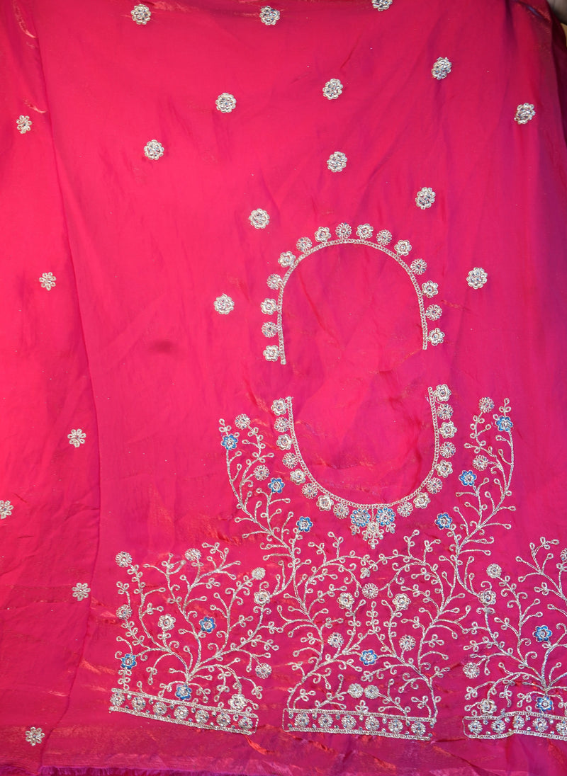 A bright pink fabric garment or textile panel with white floral embroidery and small blue and silver embellishments, shown close up with no person or real environment visible.