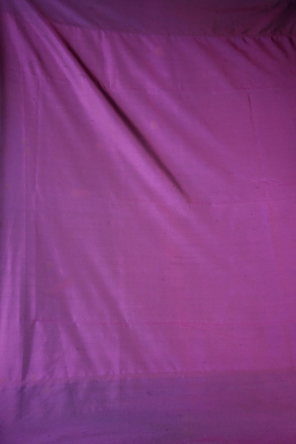 A close-up of draped purple fabric with a subtle sheen and visible folds.