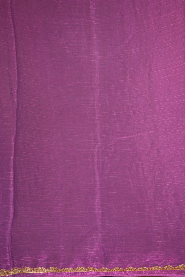 A close-up of a purple fabric with a subtle sheen and a delicate gold lace trim along the bottom edge.