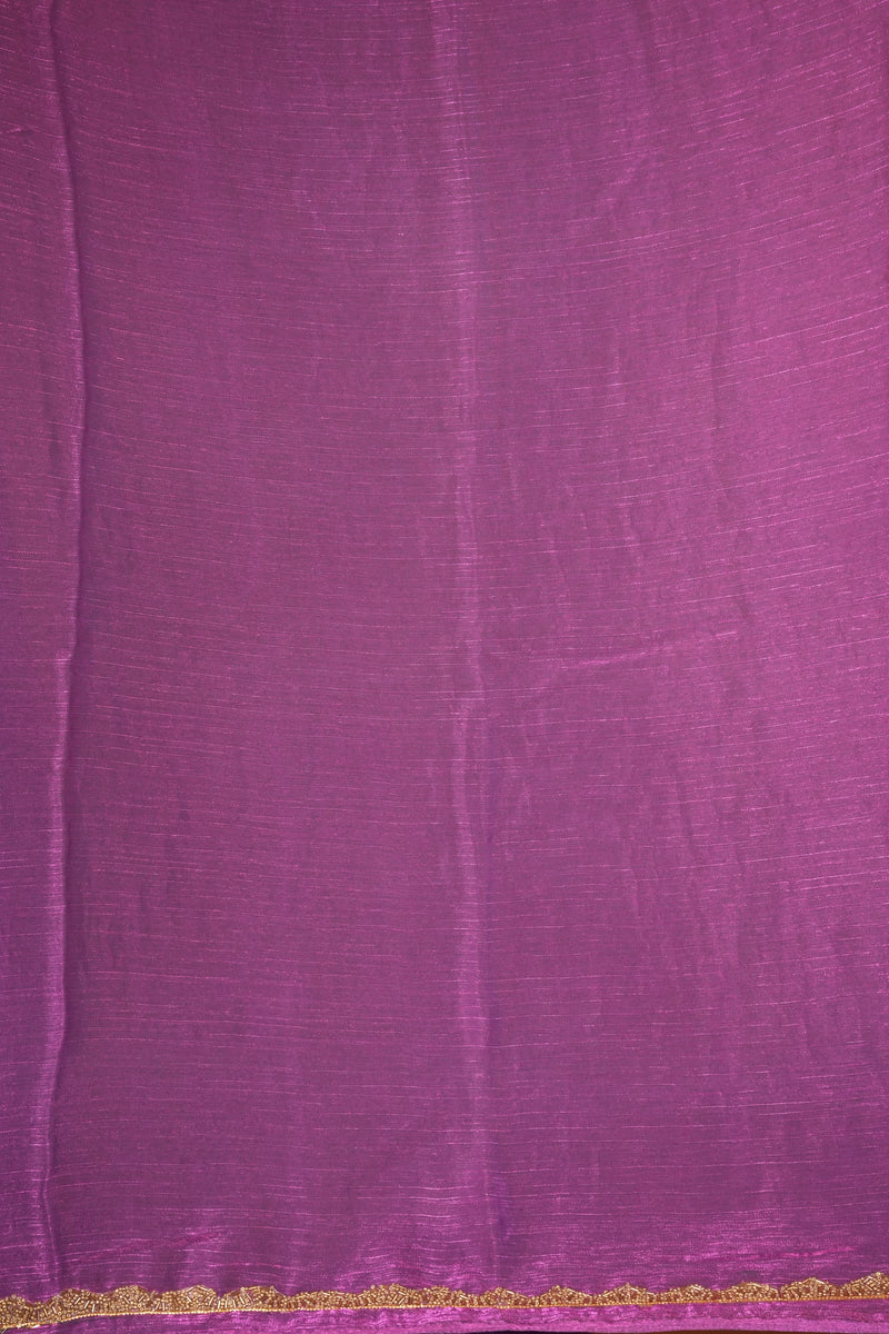 A close-up of a purple fabric with a subtle sheen and a delicate gold lace trim along the bottom edge.