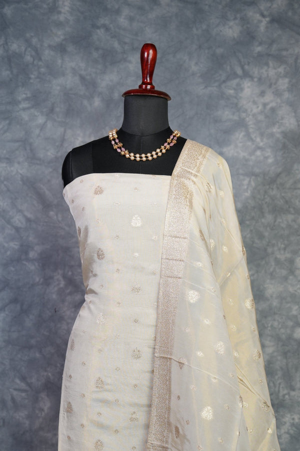 Mannequin wearing a beige dress with a textured pattern on a gray background