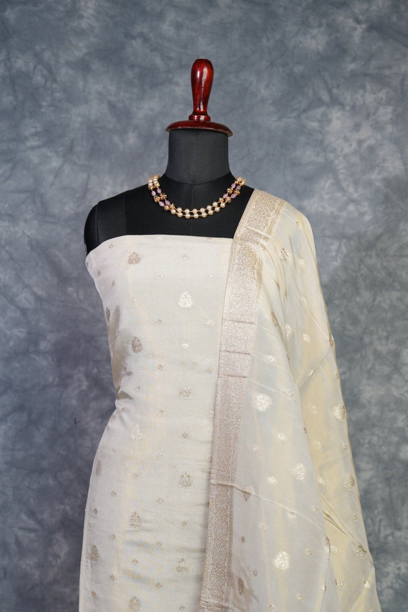 Mannequin wearing a beige dress with a textured pattern on a gray background