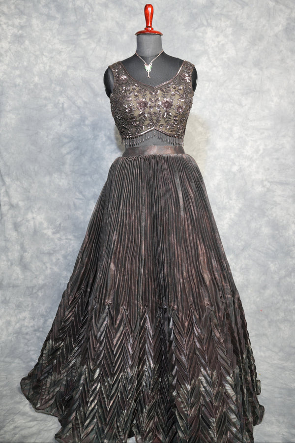 Gunmetal Pleated Lehenga Choli - A stunning gunmetal toned lehenga choli featuring sharp, structured pleats that cascade gracefully, blending contemporary edge with timeless ethnic charm.
