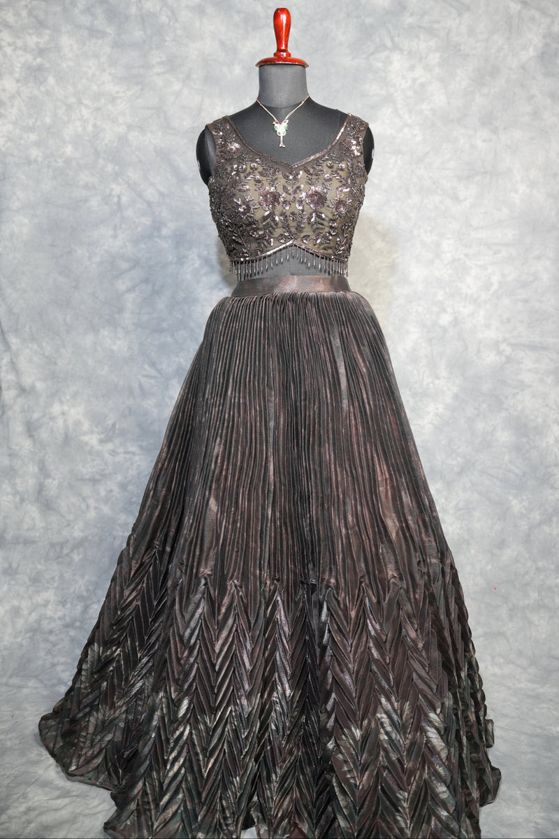 Gunmetal Pleated Lehenga Choli - A stunning gunmetal toned lehenga choli featuring sharp, structured pleats that cascade gracefully, blending contemporary edge with timeless ethnic charm.