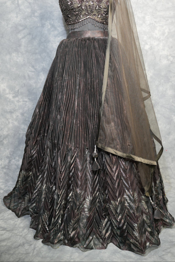 Gunmetal Pleated Lehenga Choli - A stunning gunmetal toned lehenga choli featuring sharp, structured pleats that cascade gracefully, blending contemporary edge with timeless ethnic charm.