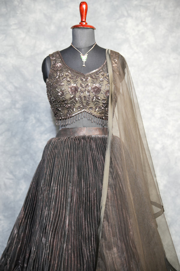 Gunmetal Pleated Lehenga Choli - A stunning gunmetal toned lehenga choli featuring sharp, structured pleats that cascade gracefully, blending contemporary edge with timeless ethnic charm.