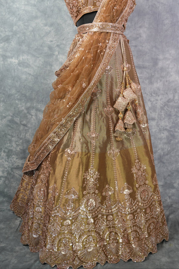 Antique Gold Lehenga Choli - with rich zari & sequin embroidery, floral medallion motifs, scalloped border, rose-gold threadwork, gracefully draped dupatta & ornate tassel detailing. Ideal for bridal & festive celebrations.
