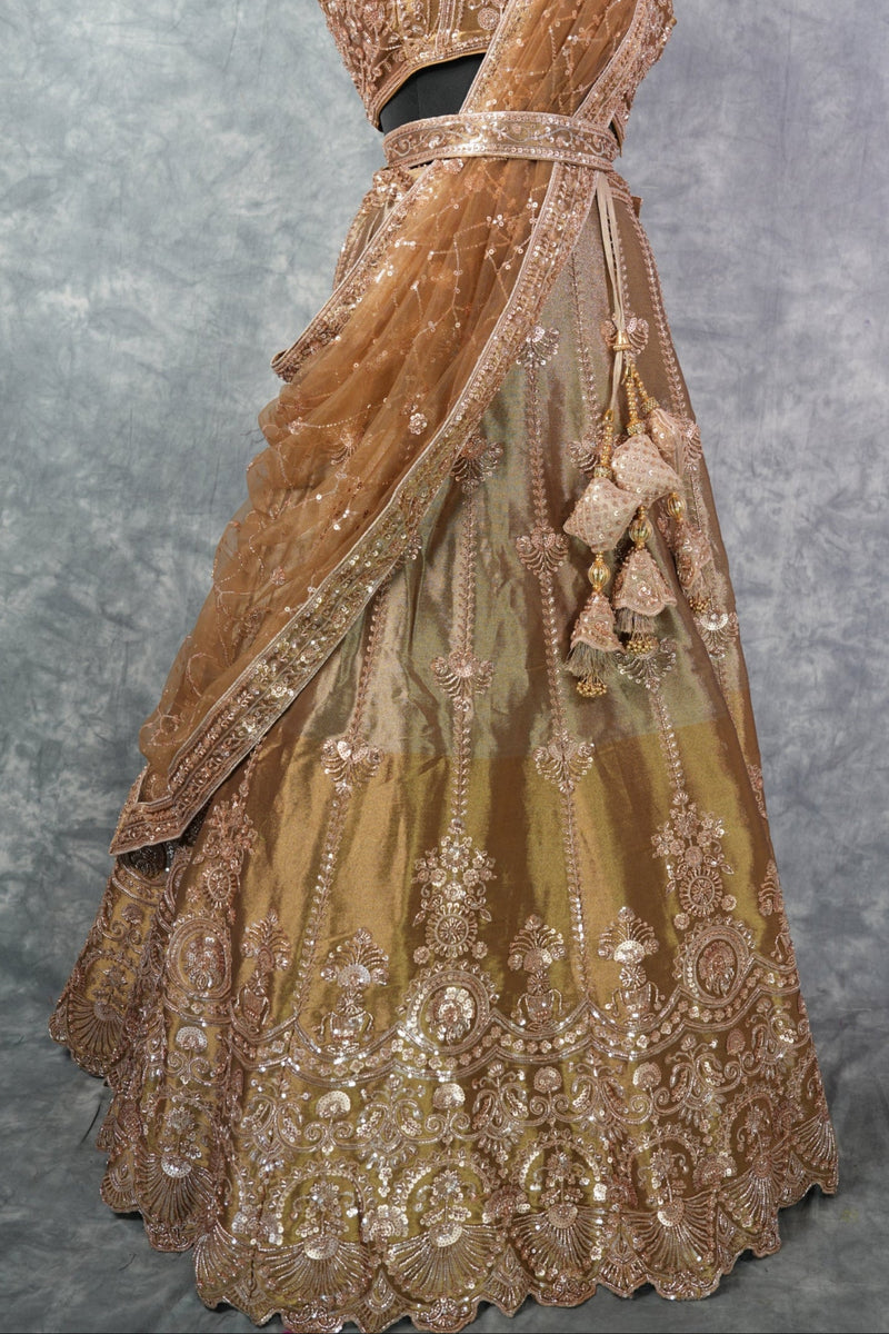 Antique Gold Lehenga Choli - with rich zari & sequin embroidery, floral medallion motifs, scalloped border, rose-gold threadwork, gracefully draped dupatta & ornate tassel detailing. Ideal for bridal & festive celebrations.