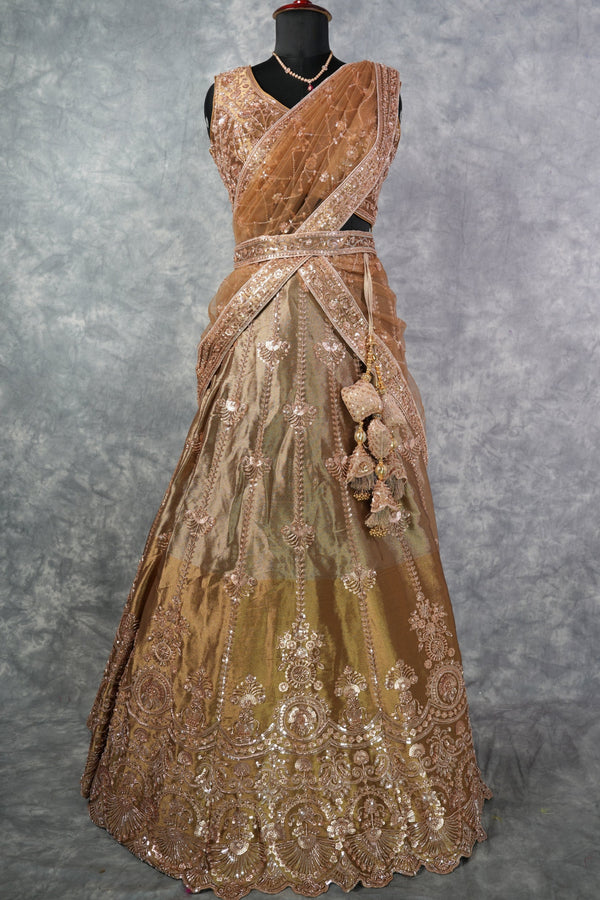 Antique Gold Lehenga Choli - with rich zari & sequin embroidery, floral medallion motifs, scalloped border, rose-gold threadwork, gracefully draped dupatta & ornate tassel detailing. Ideal for bridal & festive celebrations.