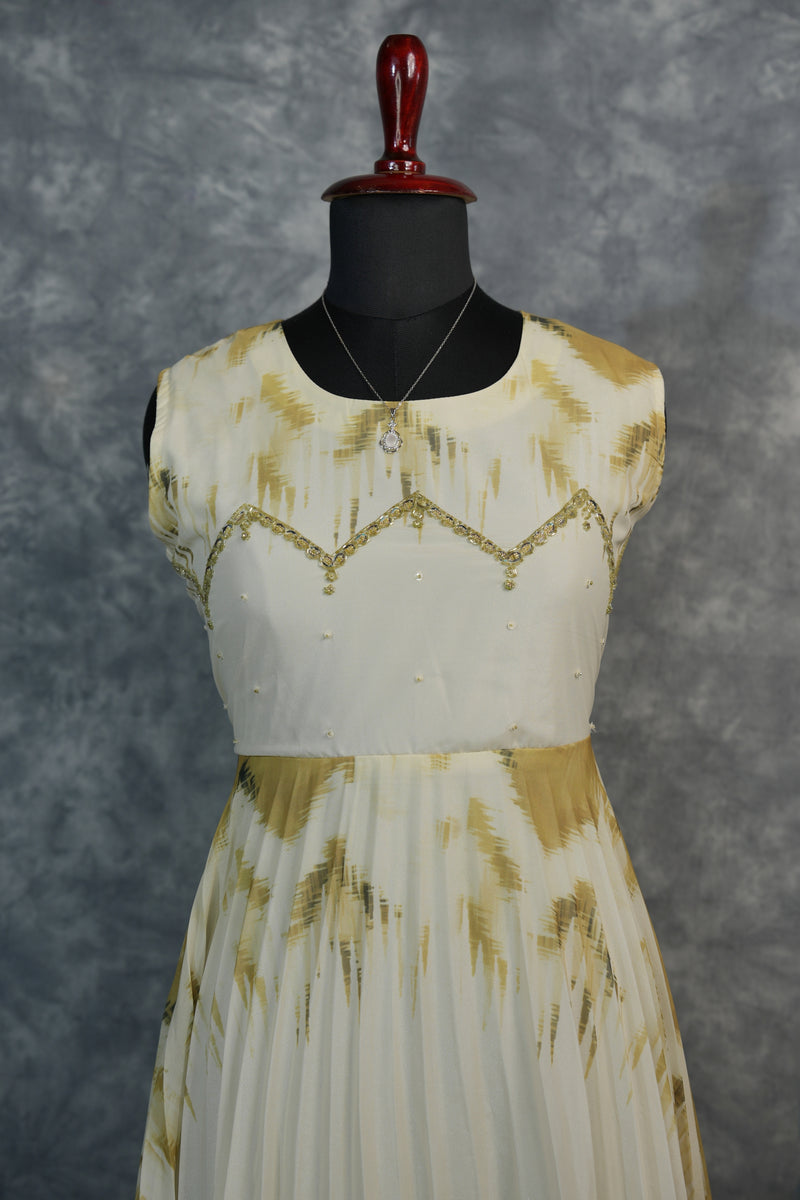 Golden Feather Chiffon Top Set — Cream chiffon with golden feather prints, pearl & stone embellishments on the neckline, flowing pleated skirt. Elegant & festive for special occasions.