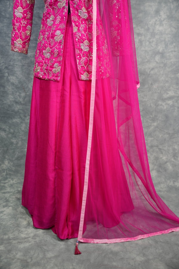 Pink traditional outfit with embroidered top on a gray surface