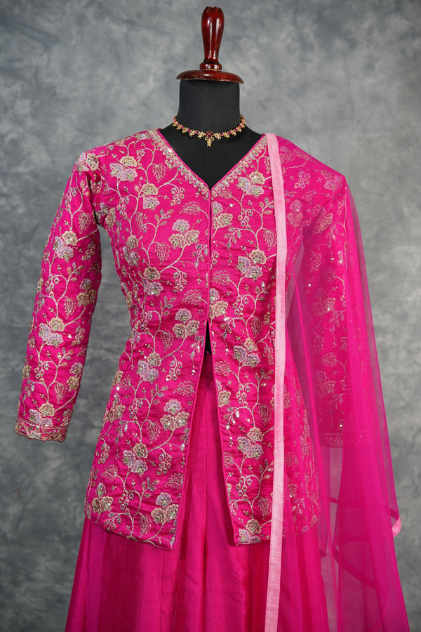Pink traditional outfit with floral patterns on a gray background