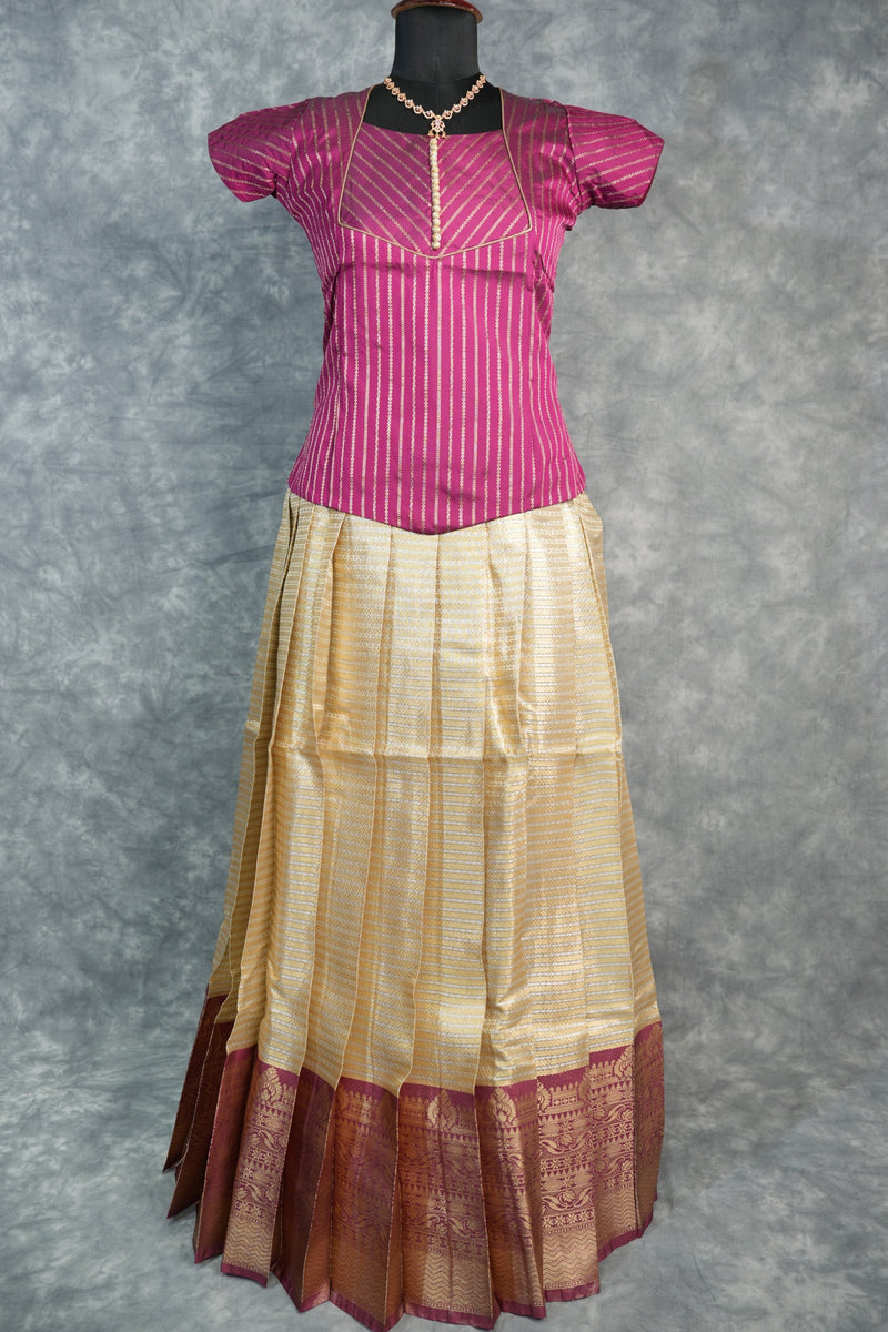 Pink and gold saree on a mannequin against a gray background