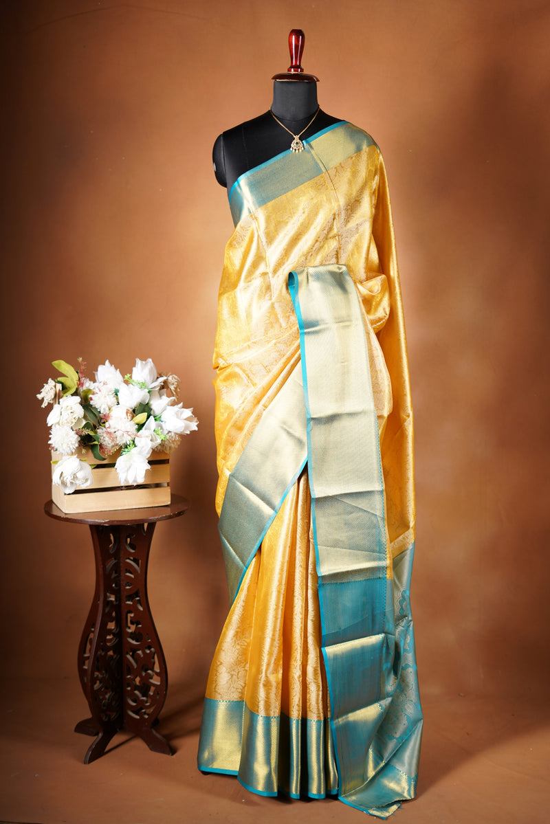 Tissue Cotton Saree - Step into effortless elegance with this radiant yellow tissue cotton saree, highlighted by a striking teal zari border with heavy zari wok in bodice and add on contrast blouse.