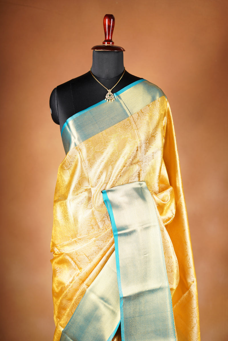 Tissue Cotton Saree - Step into effortless elegance with this radiant yellow tissue cotton saree, highlighted by a striking teal zari border with heavy zari wok in bodice and add on contrast blouse.