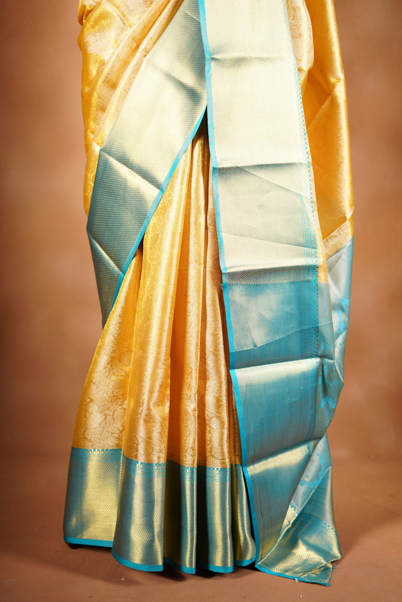 Tissue Cotton Saree - Step into effortless elegance with this radiant yellow tissue cotton saree, highlighted by a striking teal zari border with heavy zari wok in bodice and add on contrast blouse.
