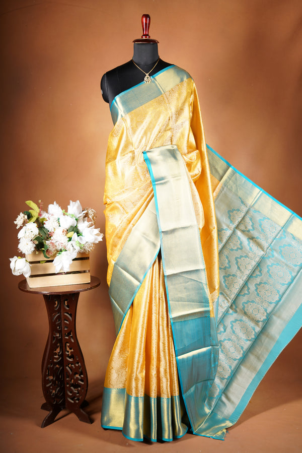 Tissue Cotton Saree - Step into effortless elegance with this radiant yellow tissue cotton saree, highlighted by a striking teal zari border with heavy zari wok in bodice and add on contrast blouse.