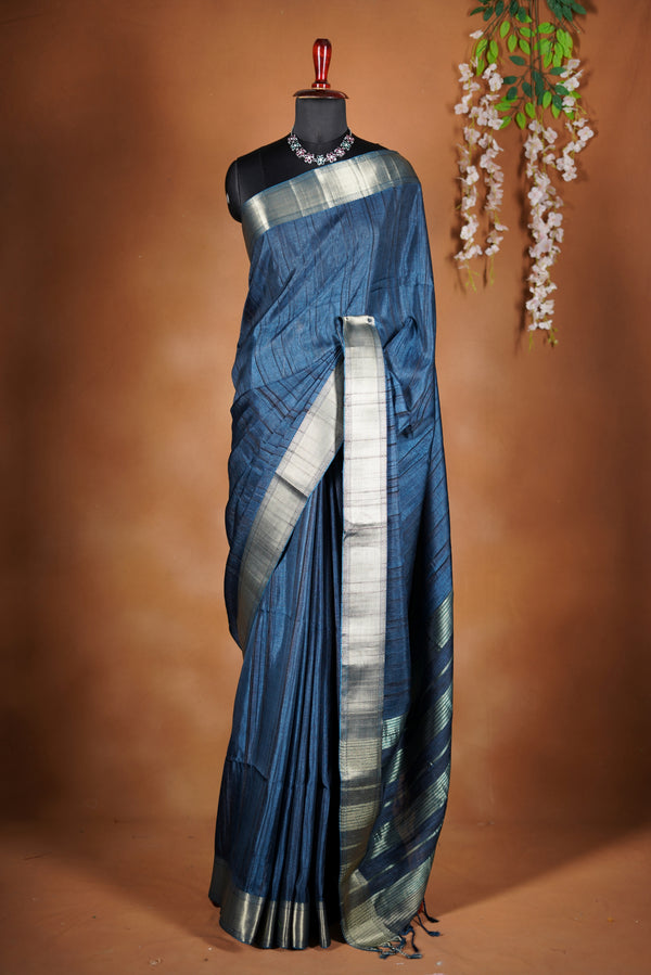 Dark slate blue Semi Tussar - Features a contrasting silver zari border and a grand pallu detailed with classic horizontal stripes and matching tassel fringe.