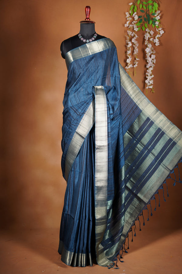 Dark slate blue Semi Tussar - Features a contrasting silver zari border and a grand pallu detailed with classic horizontal stripes and matching tassel fringe.
