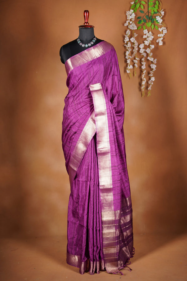 Boysenberry Semi Tussar - designed to capture attention with its luxurious appeal. The vibrant tone is enhanced by delicate texture detailing and a lustrous zari border that adds depth and richness.