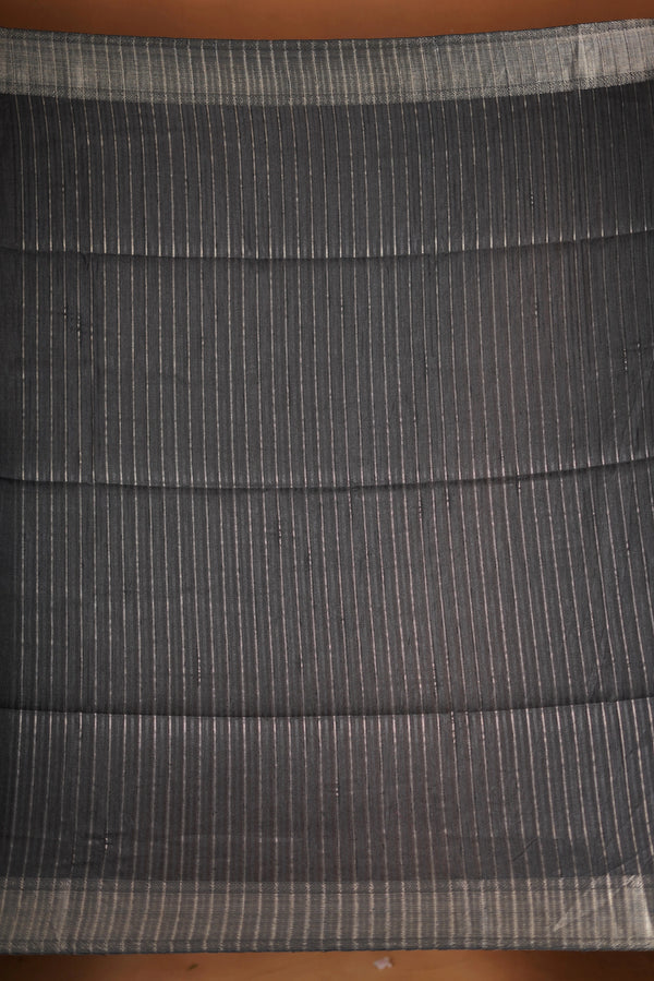 Fade Black Semi Tussar - designed to capture attention with its luxurious appeal. The vibrant tone is enhanced by delicate texture detailing and a lustrous zari border that adds depth and richness.