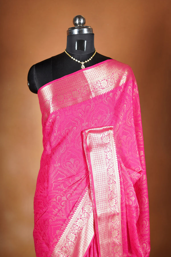 Bright Pink Geogrette Saree- Featuring all over gold floral zari weaving, rich textured patterns, and a broad gold zari border and pallu, giving a luxurious, elegant, and traditional festive look