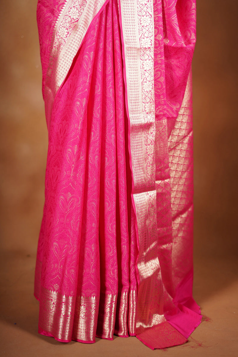 Bright Pink Geogrette Saree- Featuring all over gold floral zari weaving, rich textured patterns, and a broad gold zari border and pallu, giving a luxurious, elegant, and traditional festive look