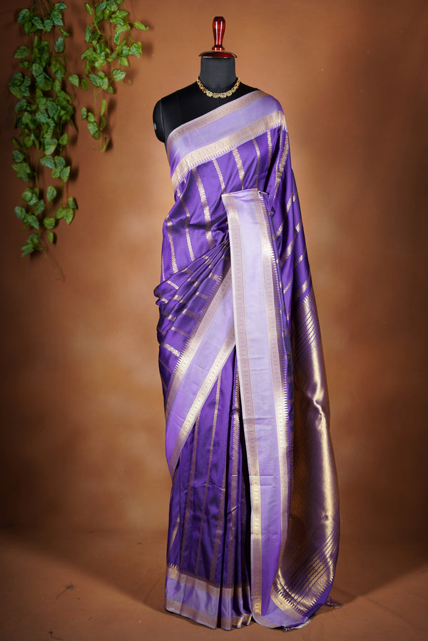 semi silk saree - Amethyst  shade with elegant gold zari stripes running across the body. It features a rich gold zari border. making it perfect for festive and special occasions