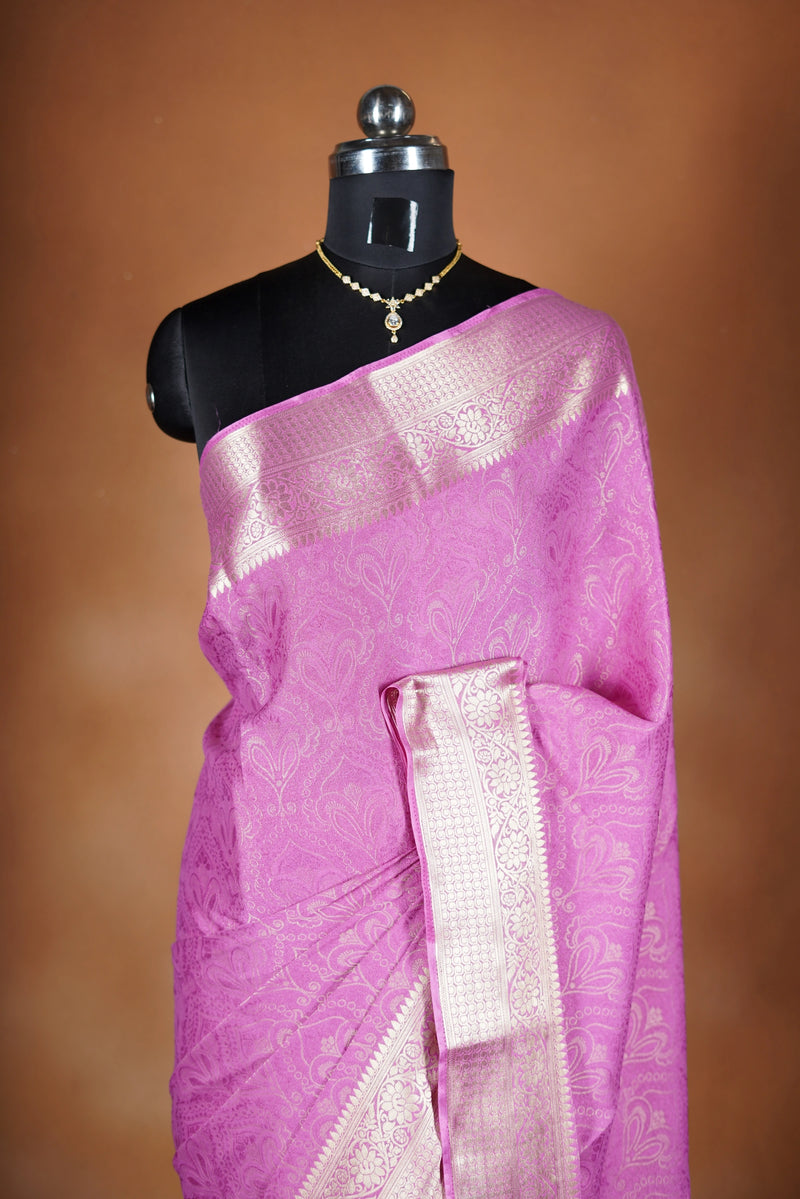 Pink Georgette Saree -  featuring a soft shimmer and intricate woven detailing the floral zari weave. The gentle pastel tone enhances its feminine charm, while the zari border adds a refined finish.