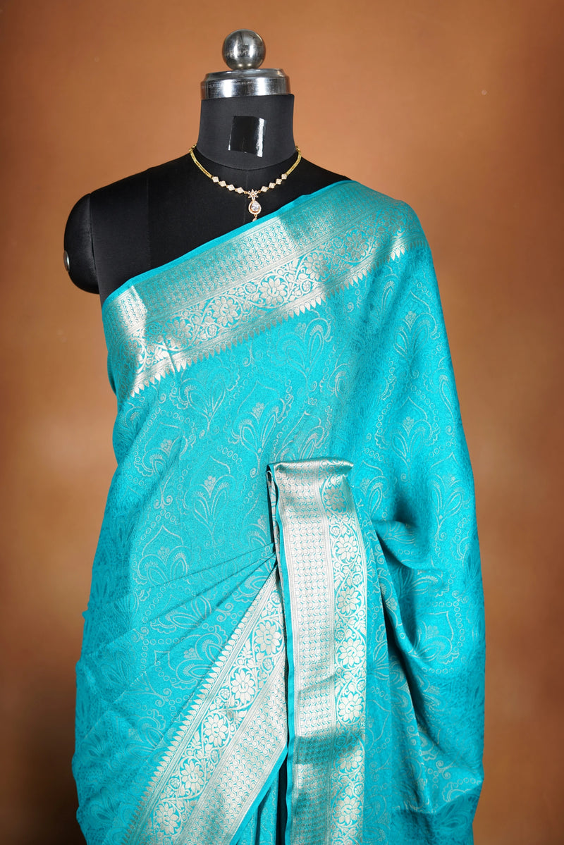 Sky blue Georgette Saree -  Featuring a soft shimmer and intricate woven detailing the floral zari weave. The gentle pastel tone enhances its feminine charm, while the zari border adds a refined finish.