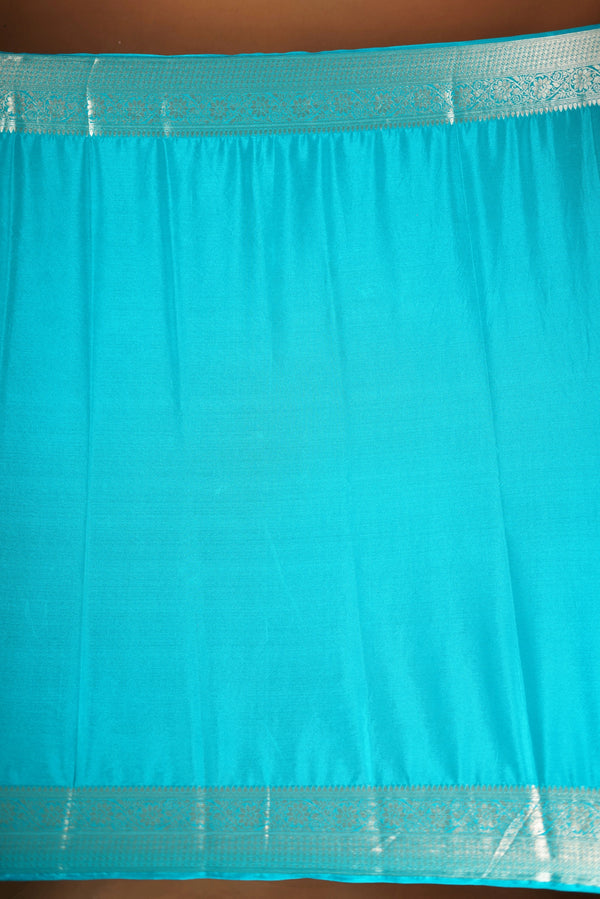 Sky blue Georgette Saree -  Featuring a soft shimmer and intricate woven detailing the floral zari weave. The gentle pastel tone enhances its feminine charm, while the zari border adds a refined finish.