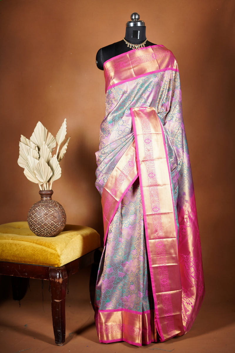Art Silk Saree - A stunning iridescent grey-silver body accented with a vibrant pink and golden border , self-textured weave with subtle floral&structured golden-pink zari border with traditional panel .