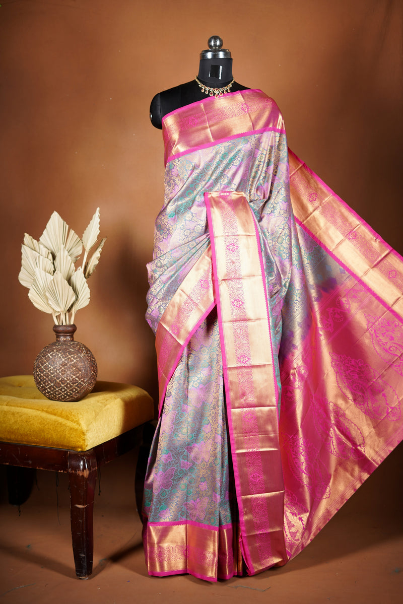 Art Silk Saree - A stunning iridescent grey-silver body accented with a vibrant pink and golden border , self-textured weave with subtle floral&structured golden-pink zari border with traditional panel .