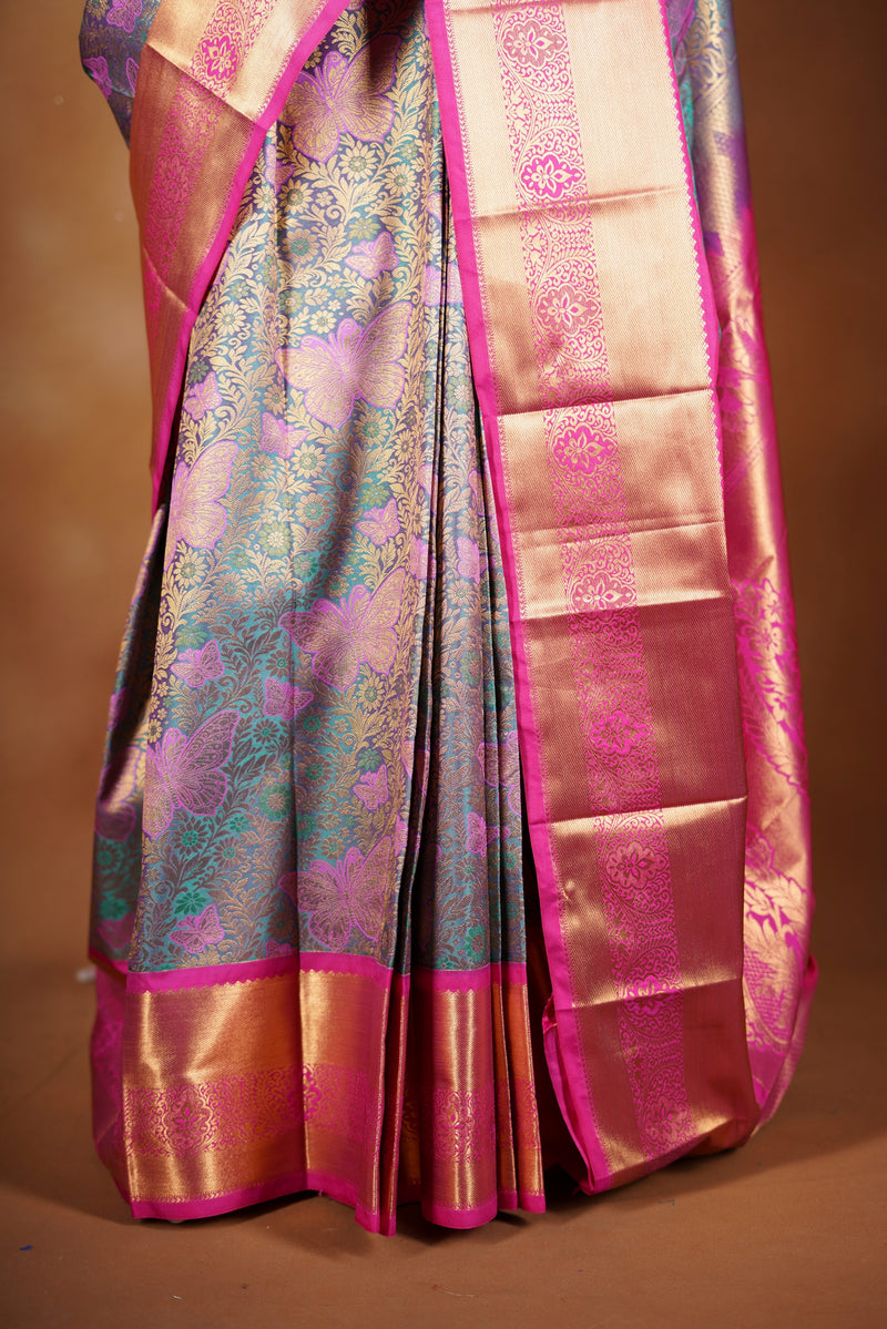 Art Silk Saree - A stunning iridescent grey-silver body accented with a vibrant pink and golden border , self-textured weave with subtle floral&structured golden-pink zari border with traditional panel .