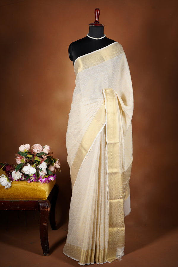 Ivory Gold Brocade Geogrette Saree- Featuring all over gold floral zari weaving, rich textured patterns, and a broad gold zari border and pallu, giving a luxurious, elegant, and traditional festive look