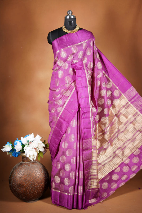 Magenta  Fancy semi jute saree - It features an elegant gold zari border with fine woven detailing and a matching zari pallu. The body has small round gold butta motifs, evenly spread for a subtle  traditional look with a matching blouse.