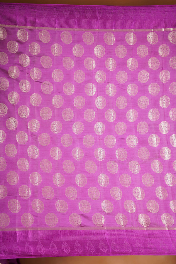 Magenta  Fancy semi jute saree - It features an elegant gold zari border with fine woven detailing and a matching zari pallu. The body has small round gold butta motifs, evenly spread for a subtle  traditional look with a matching blouse.