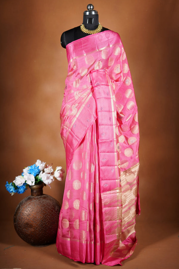 Blush Pink  Fancy semi jute saree - It features an elegant gold zari border with fine woven detailing and a matching zari pallu. The body has small round gold butta motifs, evenly spread for a subtle, graceful traditional look with a matching blouse.