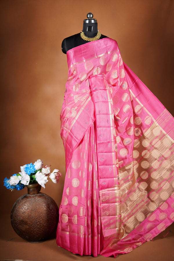Blush Pink  Fancy semi jute saree - It features an elegant gold zari border with fine woven detailing and a matching zari pallu. The body has small round gold butta motifs, evenly spread for a subtle, graceful traditional look with a matching blouse.