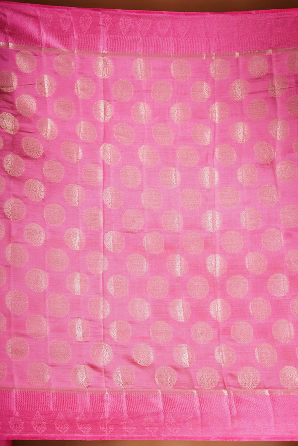Blush Pink  Fancy semi jute saree - It features an elegant gold zari border with fine woven detailing and a matching zari pallu. The body has small round gold butta motifs, evenly spread for a subtle, graceful traditional look with a matching blouse.