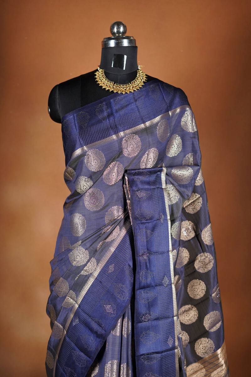 Navy blue Fancy semi jute saree - It features an elegant gold zari border with fine woven detailing and a matching zari pallu. The body has small round gold butta motifs, evenly spread for a subtle, graceful traditional look with a matching blouse.