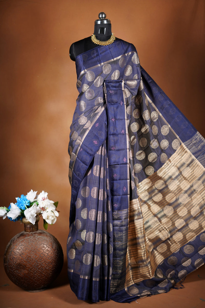 Navy blue Fancy semi jute saree - It features an elegant gold zari border with fine woven detailing and a matching zari pallu. The body has small round gold butta motifs, evenly spread for a subtle, graceful traditional look with a matching blouse.