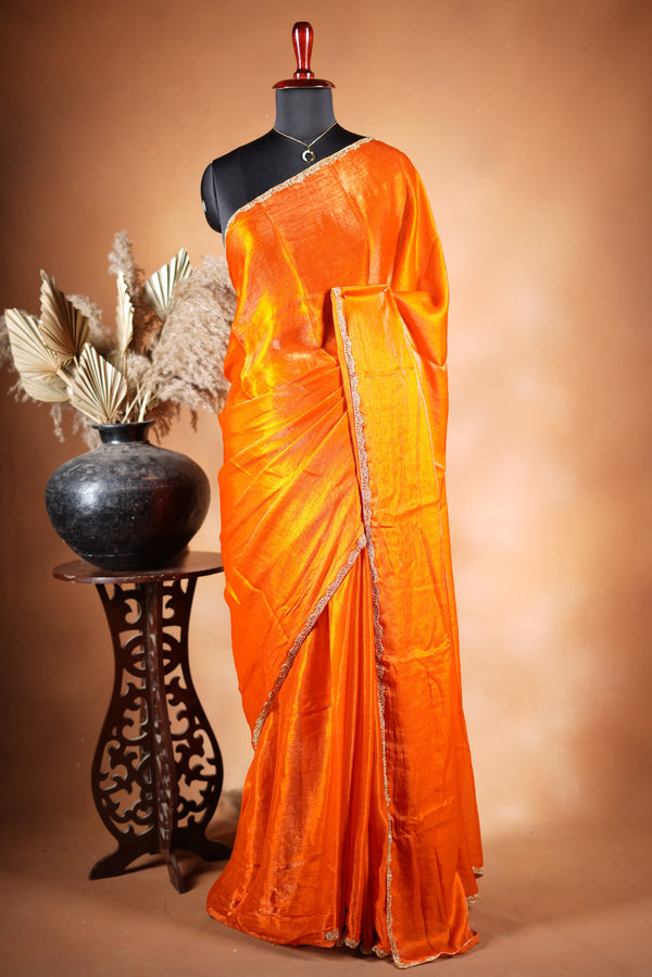 Pop Orange Space Silk Saree – Make a bold statement with this vibrant saree, featuring a smooth glossy finish. Enhanced with a delicate zari border and solid blouse, its lightweight feel blends modern style with traditional elegance for festive occasions.