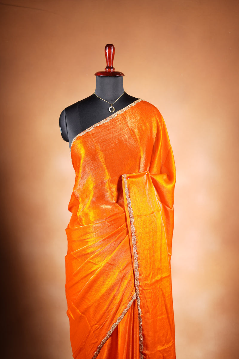 Pop Orange Space Silk Saree – Make a bold statement with this vibrant saree, featuring a smooth glossy finish. Enhanced with a delicate zari border and solid blouse, its lightweight feel blends modern style with traditional elegance for festive occasions.