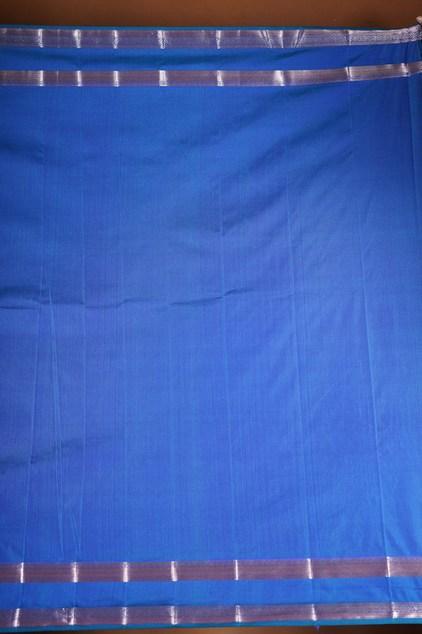 Royal blue soft silk saree featuring a modern checkered body design with elegant silver zari border and striped pallu. Lightweight and graceful, it blends contemporary geometric style with traditional elegance.
