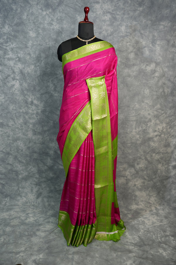 Pink and green saree on a mannequin against a gray background