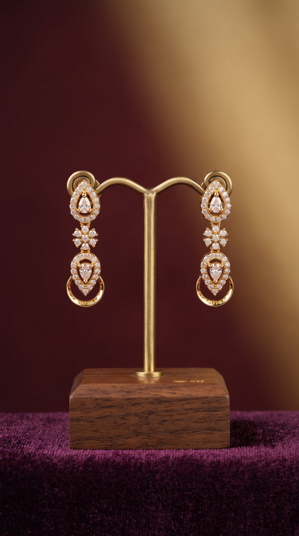 Pair of diamond earrings on a gold stand with a wooden base against a gradient background