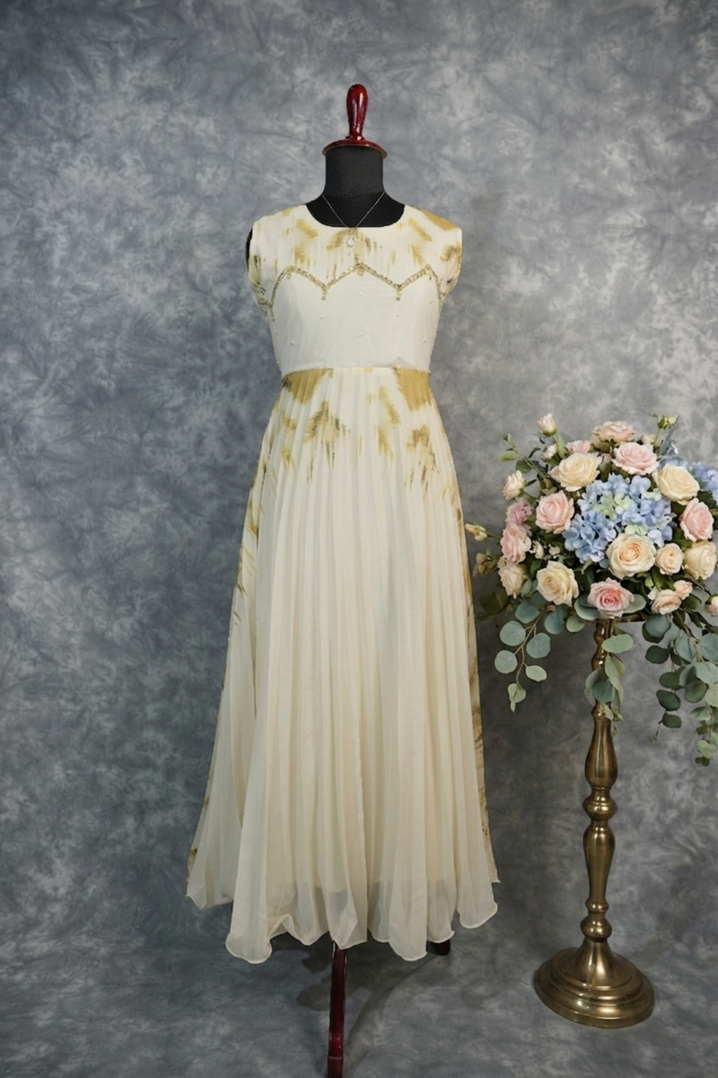 Golden Feather Chiffon Top Set — Cream chiffon with golden feather prints, pearl & stone embellishments on the neckline, flowing pleated skirt. Elegant & festive for special occasions.