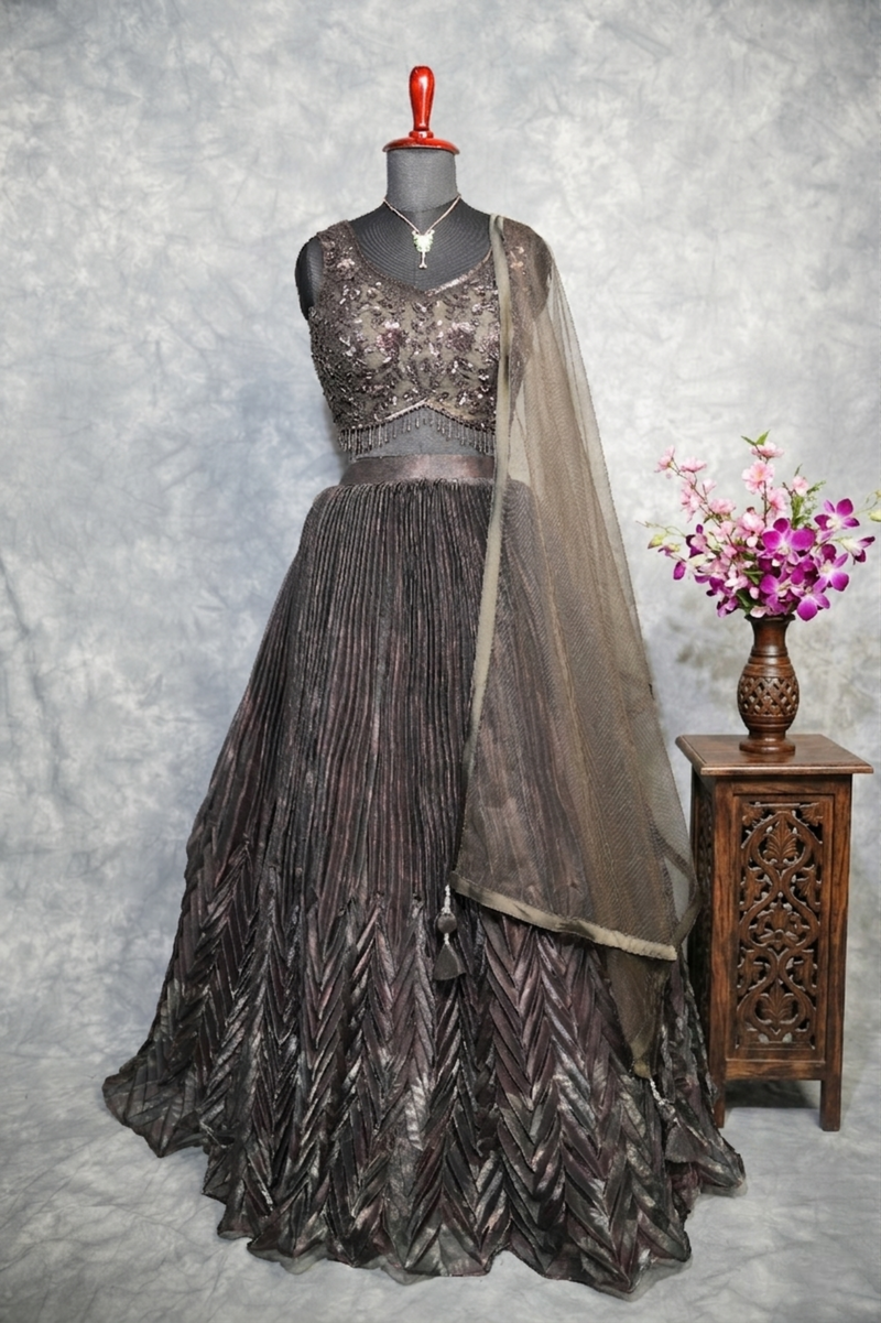 Gunmetal Pleated Lehenga Choli - A stunning gunmetal toned lehenga choli featuring sharp, structured pleats that cascade gracefully, blending contemporary edge with timeless ethnic charm.